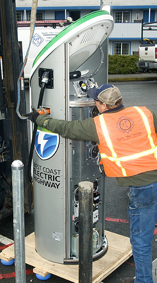 Photo of man at electric charging station.