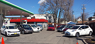 A photo of a group of electric vehicles at a charging station.