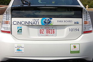 Photo of the back of a white Toyota Prius HEV with stickers advertising the City of Cincinnati and Clean Cities.