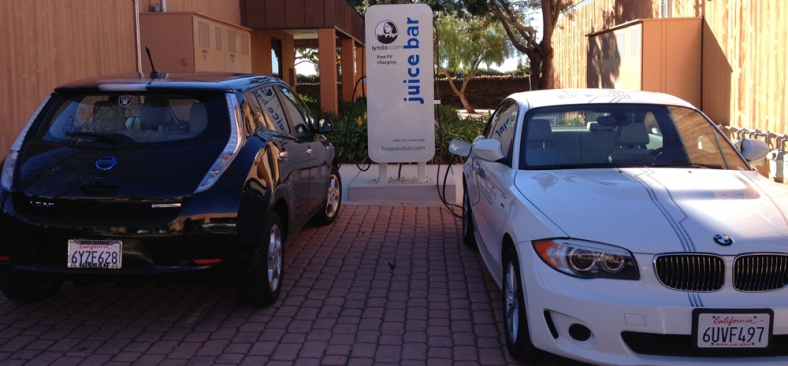 Photo of two cars plugged in to EVSE in a parking lot