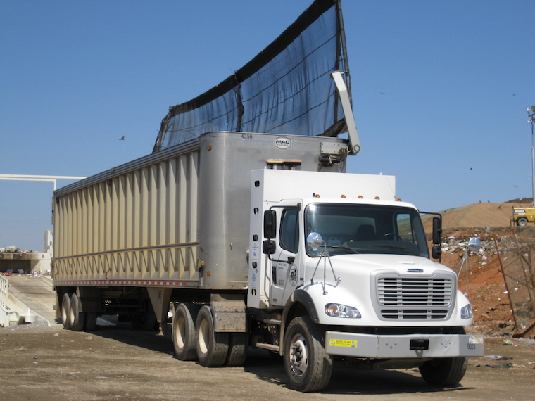 Photo of a heavy-duty compressed natural gas truck outside of a landfill.