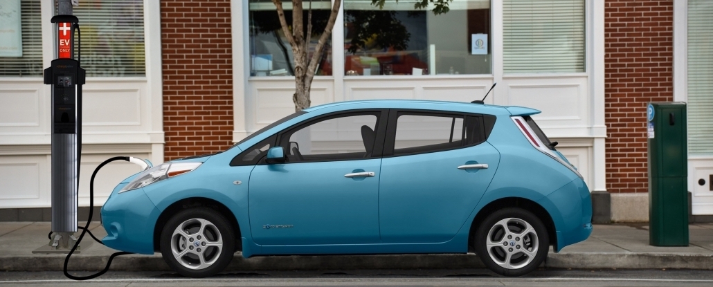 Digital rendering of a blue zero emission sedan plugged in to a streetlight EV charging.